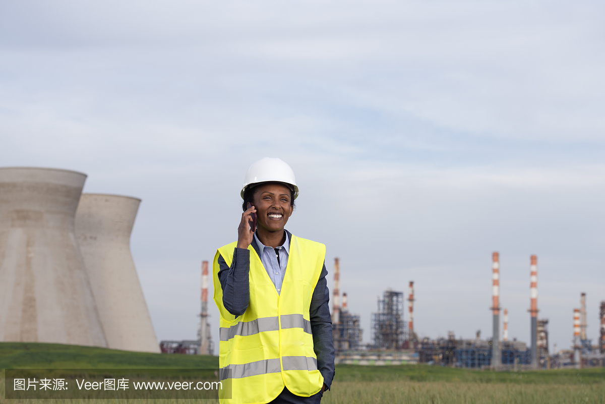在化工廠打電話的女商人。
